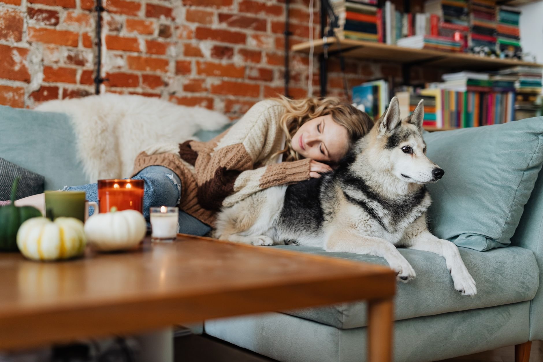 Woman resting with her dog in a cosy living room, evoking warmth and comfort.